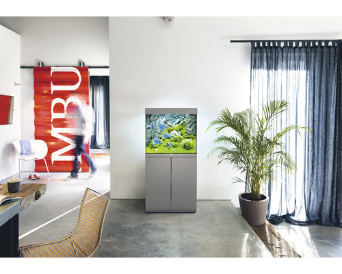 Wohnraum mit Aquarium auf Unterschrank, Zimmerpflanze und Vorhängen