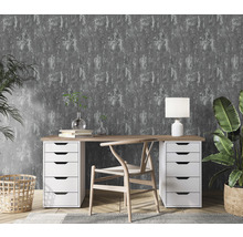 Arbeitszimmer mit Schreibtisch, Stuhl, Lampe und Zimmerpflanzen vor grauer Mustertapete