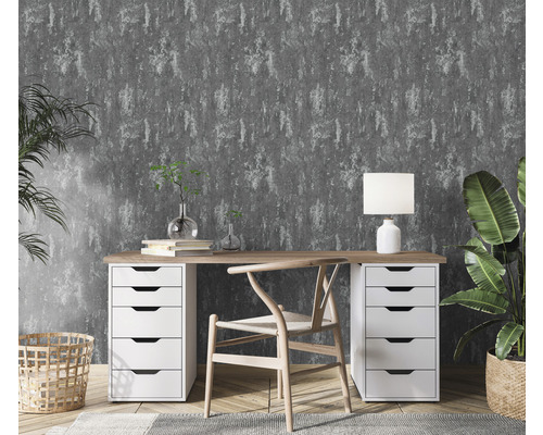 Arbeitszimmer mit Schreibtisch, Stuhl, Lampe und Zimmerpflanzen vor grauer Mustertapete