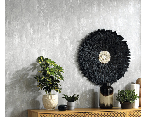 Dekoratives Interieur mit gemusterter Tapete, Kommode und Zimmerpflanzen.