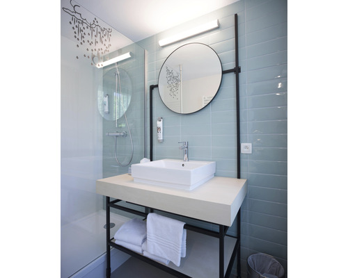 Modernes Badezimmer mit Dusche, Waschbecken, Spiegel und Handtüchern