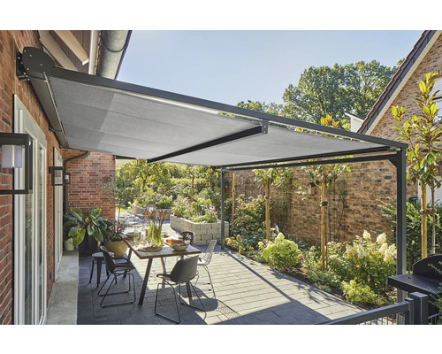 Überdachte Terrasse mit Markise, Tisch und Stühlen im Garten