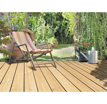 Holzterrasse mit Liegestuhl, Gartenwerkzeug und Pflanzen
