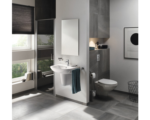 Helles Badezimmer mit Waschbecken, Spiegel, Toilette und Dusche.