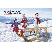 Holzschlitten vor Schneelandschaft mit spielenden Kindern und Schneemann
