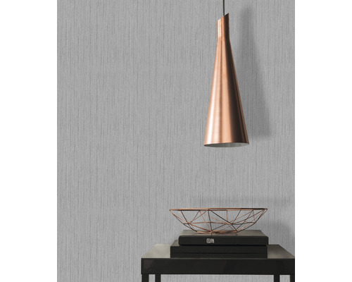 Raumszene mit grauer Tapete, Lampe und Deko auf Tisch