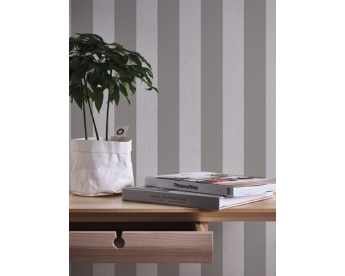 Raumansicht mit gestreifter Tapete, Pflanze und Holztisch