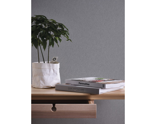 Dekoratives Arrangement mit Pflanze, Büchern und Holzschreibtisch