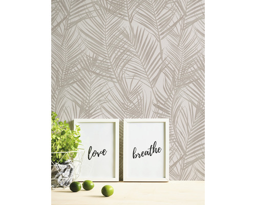 Wand mit Palmenmuster-Tapete, zwei Bilderrahmen mit den Aufschriften Liebe und Atmen