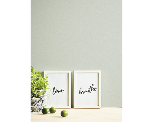 Dekorative Szene mit Kräutertopf, Zitronen und gerahmten Kunstdrucken mit den Aufschriften Liebe und Atmen.