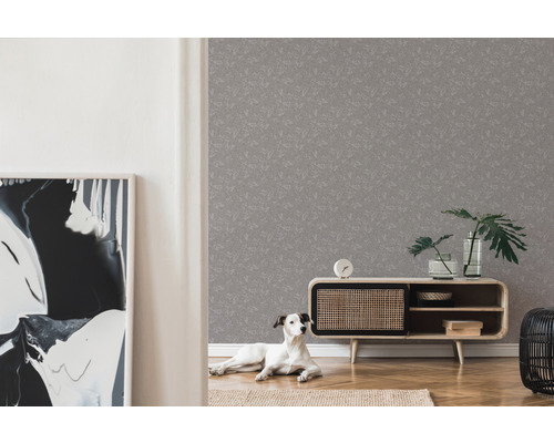 Wohnzimmer mit grauer Mustertapete, Sideboard, Zimmerpflanzen und Hund