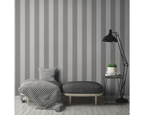 Wohnzimmer mit gestreifter Tapete, Ottomane und Stehlampe