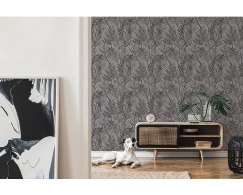 Wohnzimmer mit Tapete mit Blättermuster, Lowboard und Dekorationen sowie ein Hund auf dem Teppich