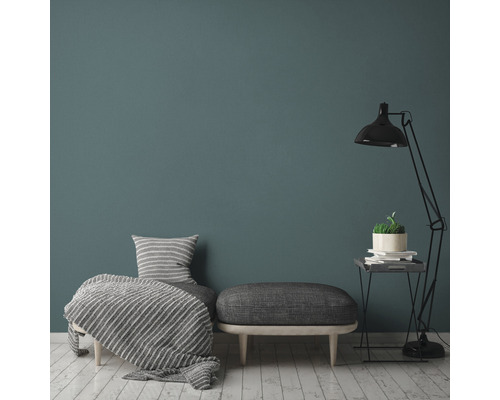 Wohnzimmer mit Sessel, Hocker, Stehlampe und Dekoration