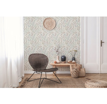 Wohnraum mit gemusterter Tapete, Rattansessel und dekorativen Accessoires für ein gemütliches Ambiente