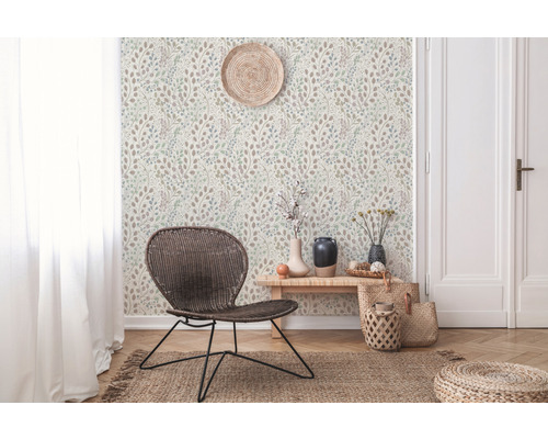 Wohnraum mit gemusterter Tapete, Rattansessel und dekorativen Accessoires für ein gemütliches Ambiente