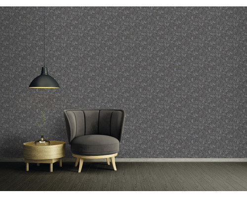 Wohnzimmer mit gemusterter Tapete, Sessel und Pendelleuchte