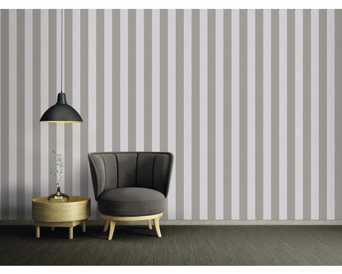 Wohnzimmer mit gestreifter Tapete, Sessel, Lampe und Beistelltisch
