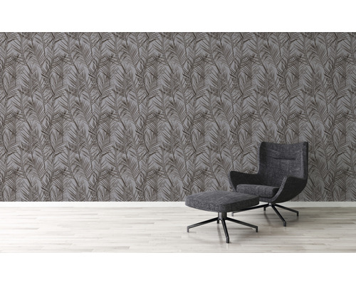 Wohnraum mit grauer Blättertapete und Sessel mit Fußhocker
