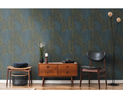 Dekoratives Interieur mit blau-goldener Blättertapete, Kommode, Stuhl und Stehlampe