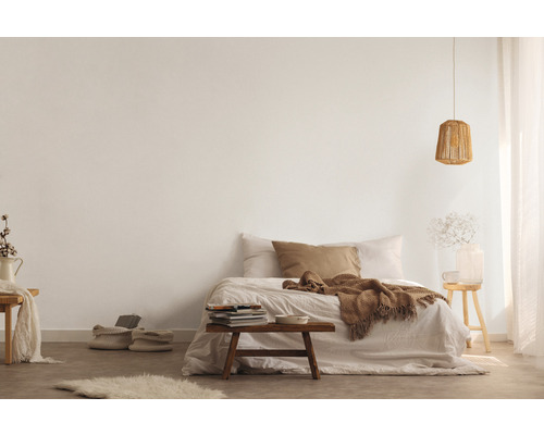 Helles Schlafzimmer mit Bett, Holzhocker und Stricklampe