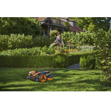 Szene mit einem Rasenmähroboter im Garten