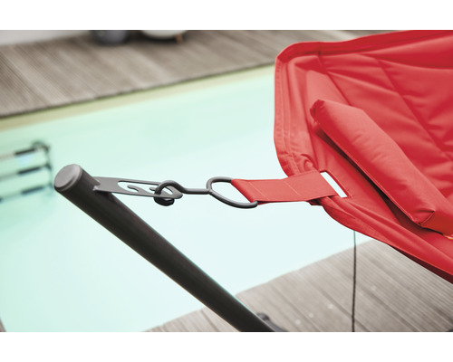 Detailaufnahme einer roten Hängematte mit Metallgestell neben einem Schwimmbecken