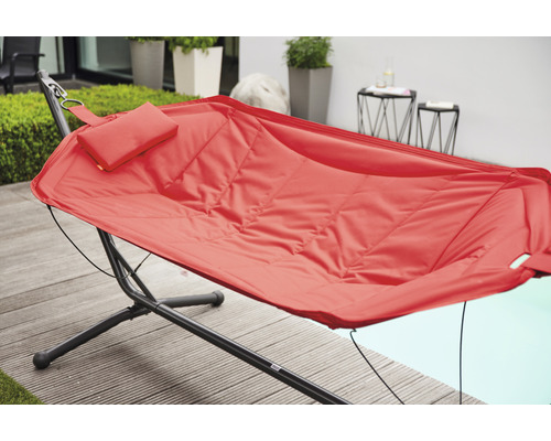 Rote Hängematte mit Kissen auf einem schwarzen Metallgestell im Außenbereich