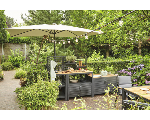 Garten mit Outdoor-Küche, Sonnenschirm und Lichterkette für eine gemütliche Atmosphäre