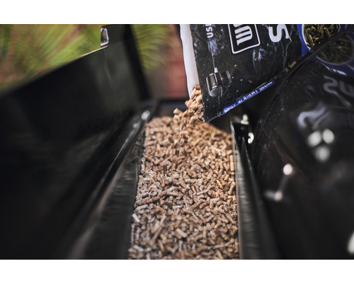 Holzpellets werden in einen Pelletgrillbehälter gegossen