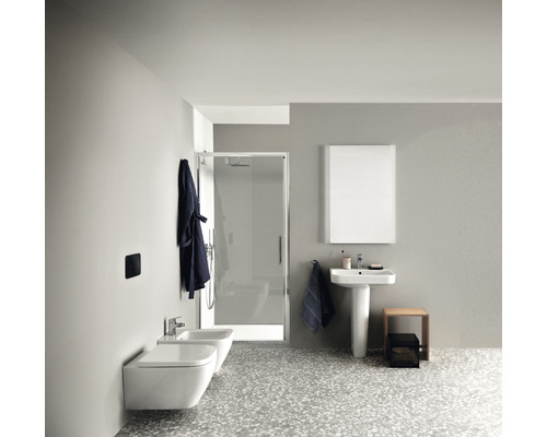 Helles Badezimmer mit Dusche, Waschtisch, Spiegel, Toilette und Bidet.