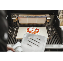 Grill mit Pizzastein und Pizza mit Tomatensoße und Käse