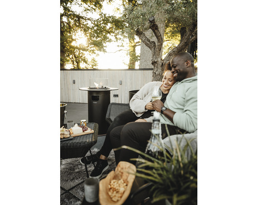 Paar genießt Zeit im Freien mit Terrassenheizstrahler, Snacks und Getränken