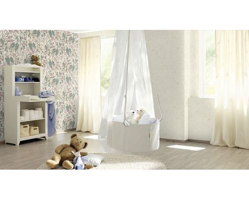 Babyzimmer mit Wickelkommode, Himmelbett und floraler Tapete