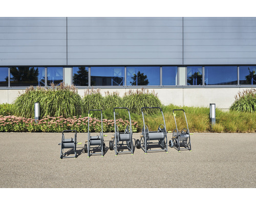 Reihe von Gartenschlauchwagen verschiedener Größe vor einem Gebäude