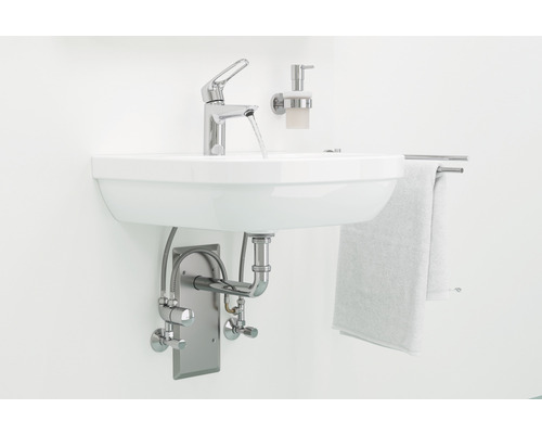 Waschbecken mit Armatur, Seifenspender und Handtuchhalter im Badezimmer