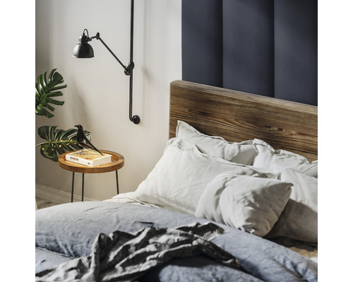 Schlafzimmer mit Holzbettgestell, Nachttisch, Leselampe und Dekoration