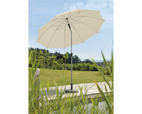 Beigefarbener Sonnenschirm auf einer Terrasse mit Gartenblick