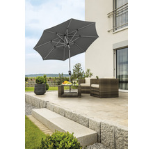 Szene mit einem Gartenschirm, Terrassenmöbeln und Pflanzen auf einer Steinterrasse.