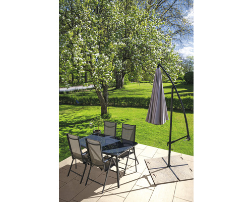 Gartenszene mit Esstisch, Stühlen und einem Sonnenschirm auf einer Terrasse