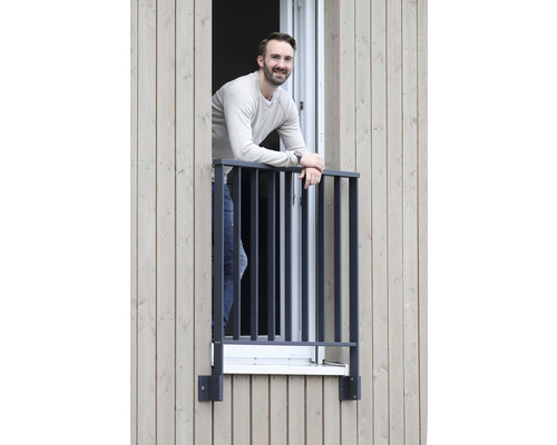 Person steht an einem Fenster mit einem Metallgeländer