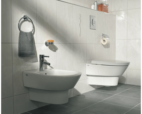 Badezimmer mit Bidet, Toilette und Badaccessoires an der Wand