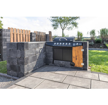 Außenküche mit Grill, gebaut aus grauen Betonsteinen und Holzelementen, im Garten