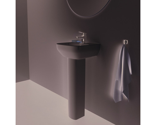 Waschtisch mit Säule, Armatur und Handtuch im Badezimmer