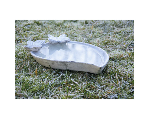Vogeltränke aus Stein mit Schmetterlingsmotiven im Garten