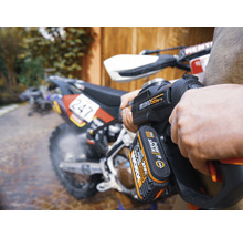 Eine Person reinigt ein Motorrad mit einem Akku-Hochdruckreiniger.