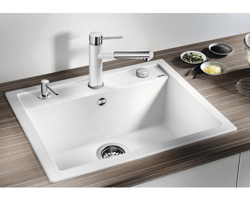 Spüle mit Armatur und Spülmittelspender auf einer Küchentheke.