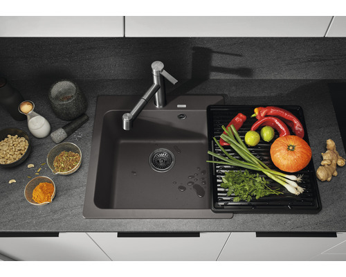 Spüle mit Abtropffläche, Armatur und frischen Zutaten auf der Arbeitsfläche