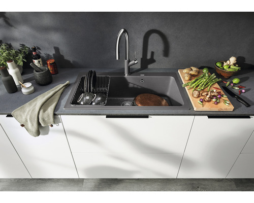 Küchenszene mit Spüle, Armatur, Geschirr und Lebensmitteln auf einer Arbeitsplatte