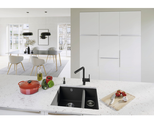 Helle Küche mit Spüle, Armatur, Kochtopf und Esstisch